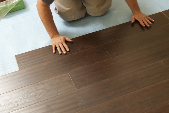 man Installing vinyl flooring at home