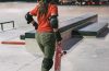 picture of a girl holding a skateboard, wearing protective gear