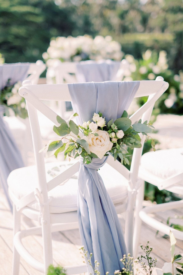 dusty blue rustic wedding decor with white rose on chair