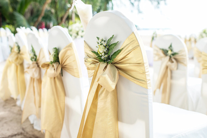 satin chair sashes with golden satin ribbons and white flowers