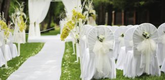 white wedding chairs covers with ribbon and white flowers