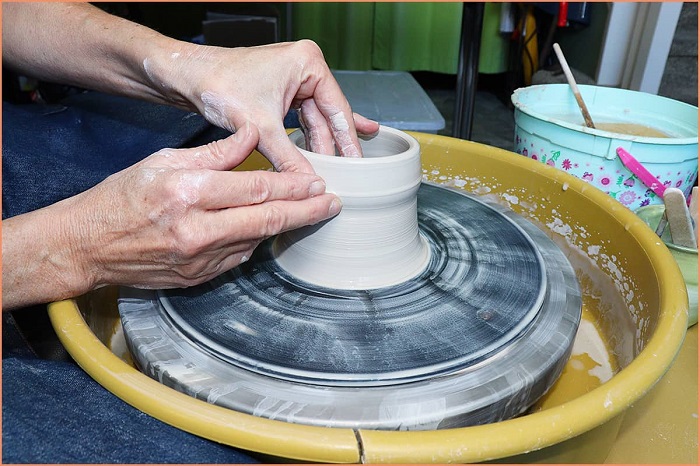 potter sculpting his artwork on a pottery wheel