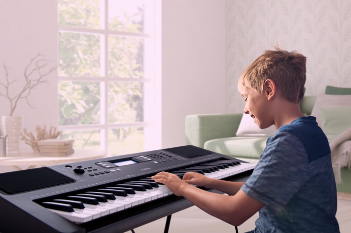 kid playing on a digital keyboard