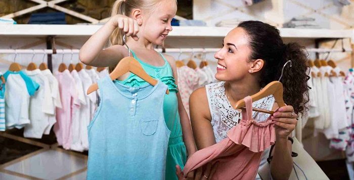 mom and daughter choosing clothes in girls clothing stores